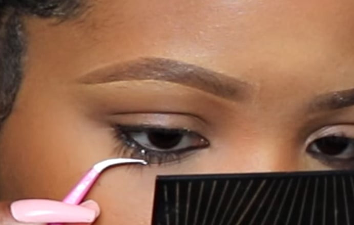 Lower lash extension: step 2, pull up the upper lashes so that they don’t interfere with the lower lashes