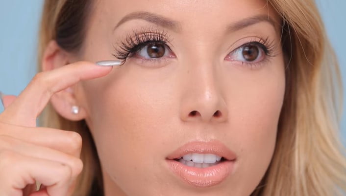 How To Trim Eyelashes: Step 3, use tweezers to grab the point on your eyelash strip that extends past the outer edge of your eye
