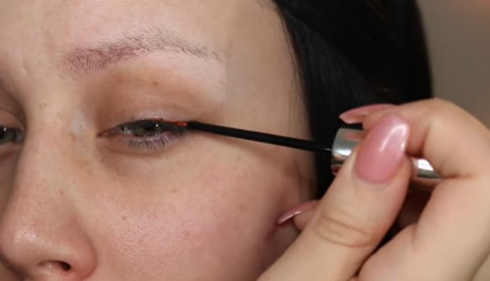 Boostlash reviews: woman showing the correct use of boostlash serum on her upper eyelids